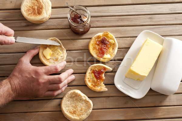 Man buttering a crumpet for breakfast Stock photo © photohome