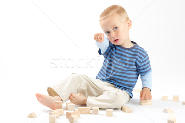 Little cute boy playing with building blocks. Isolated on white. Stock photo © Photoline
