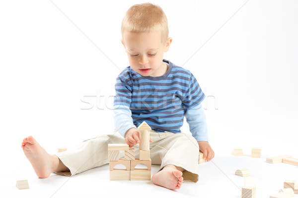 Little cute boy playing with building blocks. Isolated on white. Stock photo © Photoline