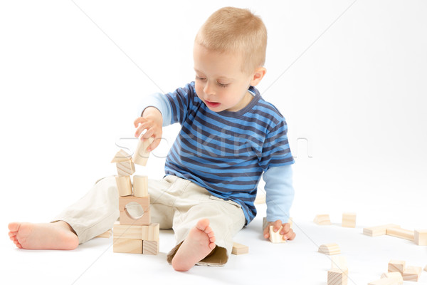 Little cute boy playing with building blocks. Isolated on white. Stock photo © Photoline