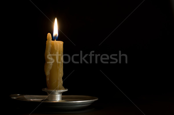 Antique metal candlestick with burning candle on black backgroun Stock photo © Photooiasson