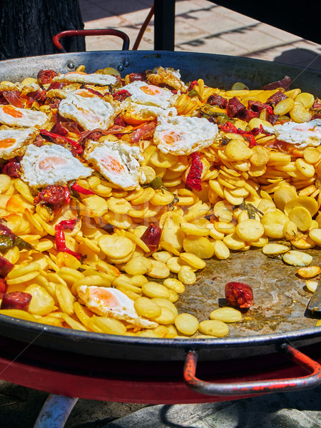 Spanish eggs with chorizo, potatoes and peppers to the frying pan. Stock photo © Photooiasson