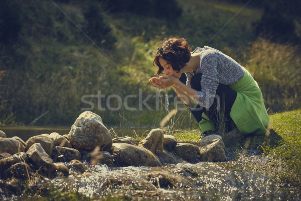 Woman drinking mountain stream water Stock photo © photosebia