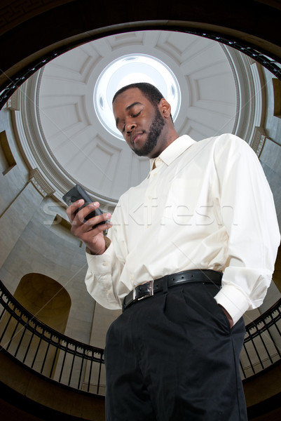 üzletember sms chat fekete afroamerikai mobiltelefon iroda Stock fotó © piedmontphoto