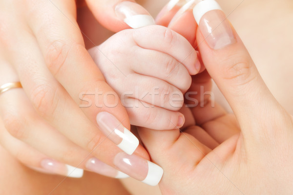 Mother holding her Baby's hands . Stock photo © Pilgrimego