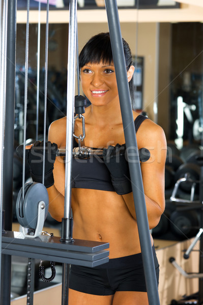 Beautiful woman is doing exercises at the gym Stock photo © Pilgrimego