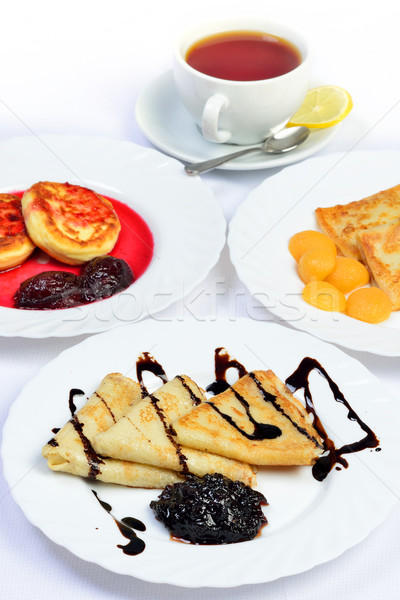 Food of Crepes, cheesecakes with berry sause and cup of tee. Stock photo © Pilgrimego