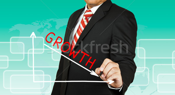 Businessman drawing a graph with Growth going down Stock photo © pinkblue