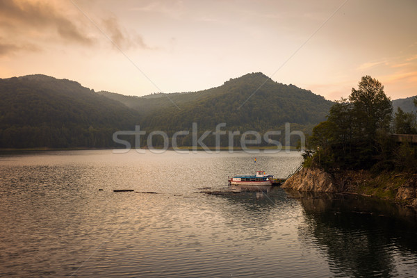 Small boat on the artificial lake behind the Bicaz Dam, at sunse Stock photo © pixachi
