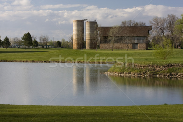 barn with two silos surrounded by green meadows and lake Stock photo © PixelsAway