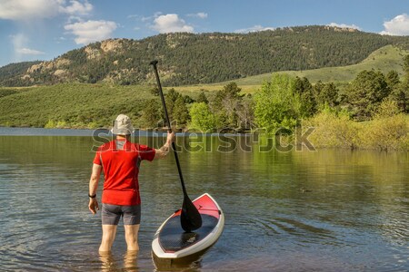 male paddler with SUP paddleboard on lake Stock photo © PixelsAway