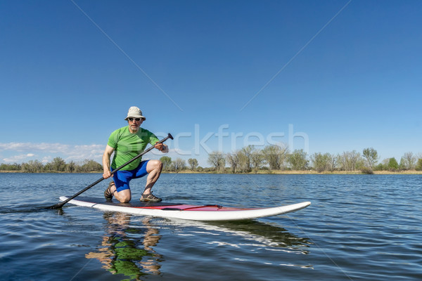 senior male on stand up paddleboard Stock photo © PixelsAway