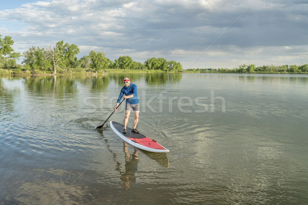 senior paddler on stand up paddleboard Stock photo © PixelsAway