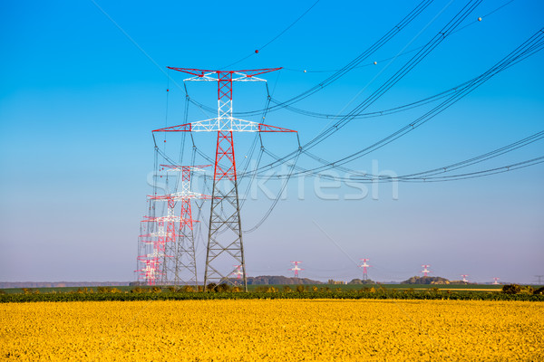 Stock photo: Electricity transmission pylon silhouetted against blue