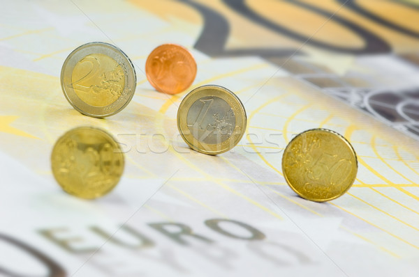 Euro coins rolling over a 200-euro-banknote Stock photo © pixpack