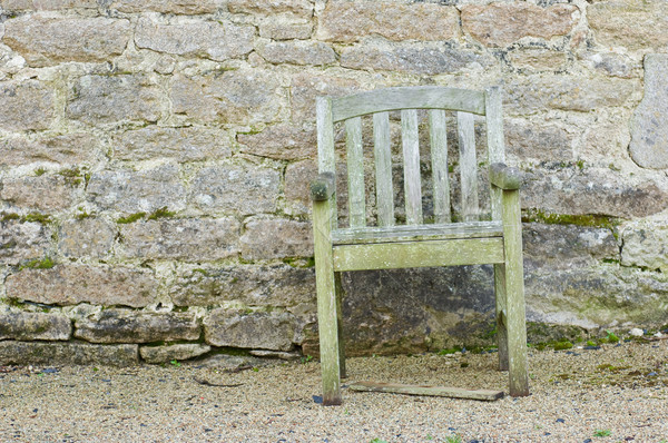 Stock photo: Rotten chair in front of a wall