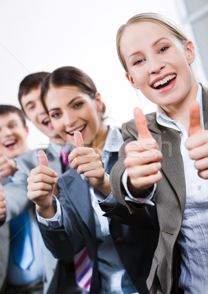 Vertical image of business people giving the thumbs-up sign Stock photo © pressmaster