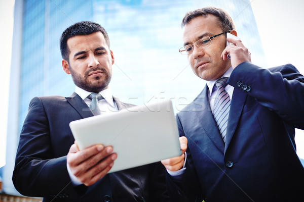Mobiele onderhandelingen ervaren zakenlieden bespreken details Stockfoto © pressmaster