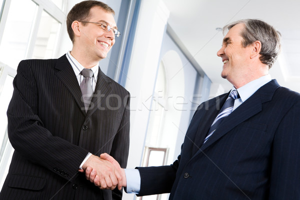 Salut portret oameni de afaceri strângere de mână alte coridor Imagine de stoc © pressmaster