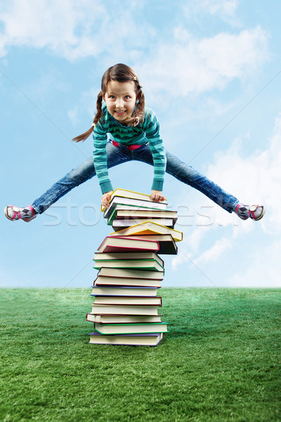 Imagine fata de fericit jumping iarbă cărţi Imagine de stoc © pressmaster