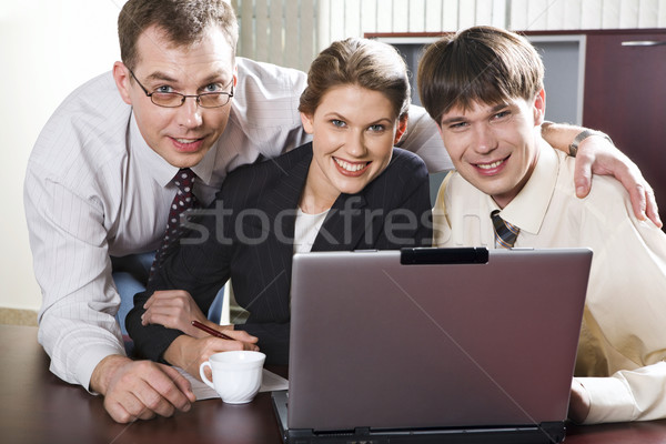 Zespołowej trzy uśmiechnięty biznesmenów tabeli patrząc Zdjęcia stock © pressmaster
