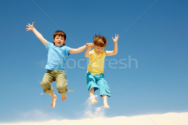 Zabawy Fotografia szczęśliwy chłopców skoki plaża piaszczysta Zdjęcia stock © pressmaster