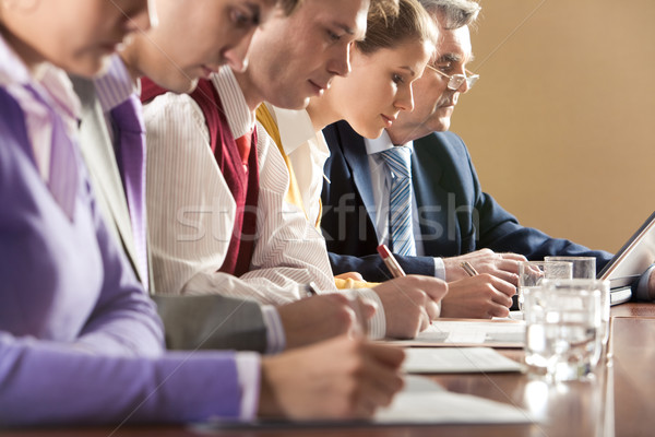 Briefing rangée gens d'affaires écrit travaux supérieurs Photo stock © pressmaster