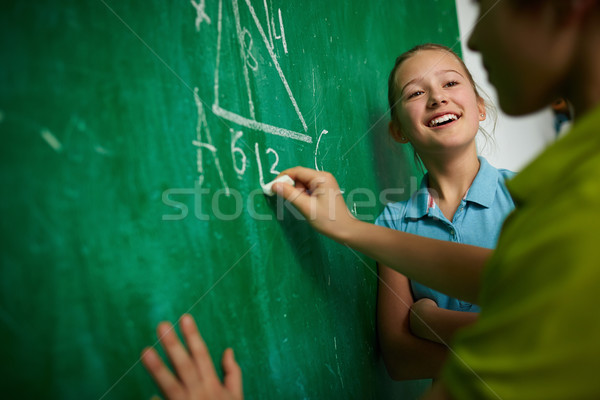 Exitoso colegiala niña feliz mirando compañero de clase pizarra Foto stock © pressmaster