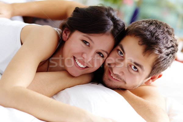 Proximidade feliz casal cama olhando câmera Foto stock © pressmaster