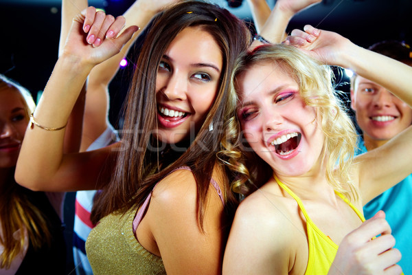 Dansuri petrecere doua vesel fete club de noapte Imagine de stoc © pressmaster