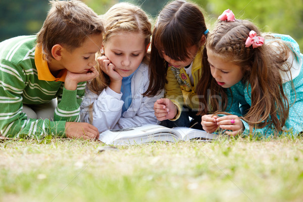 Timp în aer liber portret drăguţ copii lectură Imagine de stoc © pressmaster