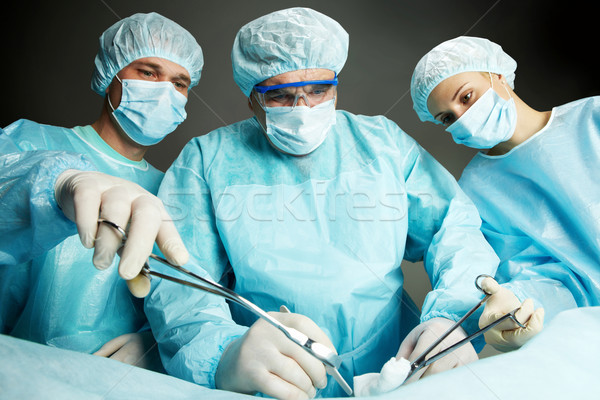 Operação três cirurgiões trabalhando escuro mulher Foto stock © pressmaster