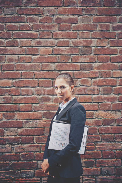 Imagine supărat femeie de afaceri document mers zid de cărămidă Imagine de stoc © pressmaster
