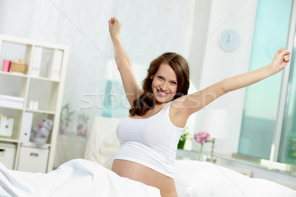 ébredés fotó csinos terhes nő ágy néz Stock fotó © pressmaster