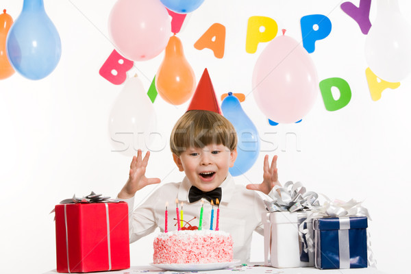 Rapaz retrato surpreendido mãos acima bolo de aniversário Foto stock © pressmaster