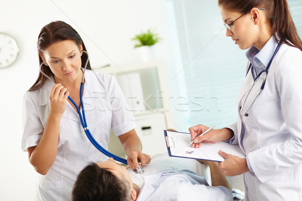 Serca egzamin lekarza słuchania kobieta człowiek Zdjęcia stock © pressmaster