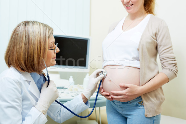 Gynaecoloog volwassen onderzoeken buik zwangere jonge vrouw Stockfoto © pressmaster