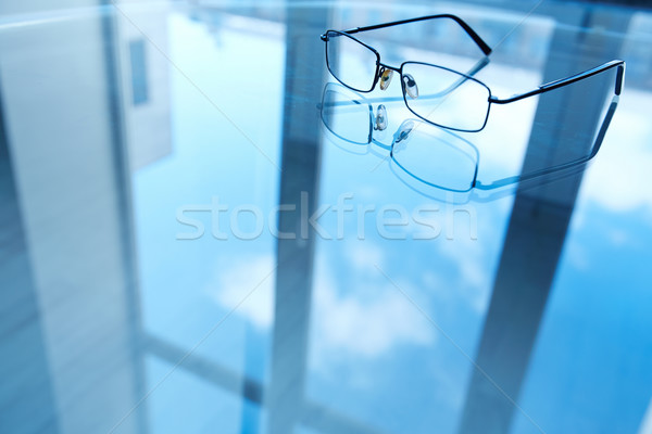 Eyeglasses on reflective surface Stock photo © pressmaster