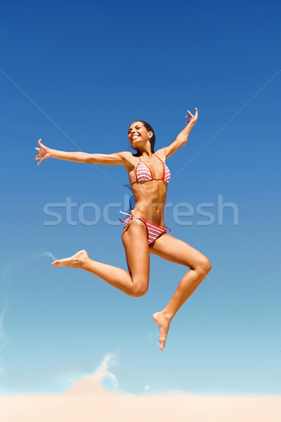 Powietrza Fotografia młodych happy girl plaża piaszczysta jasne Zdjęcia stock © pressmaster