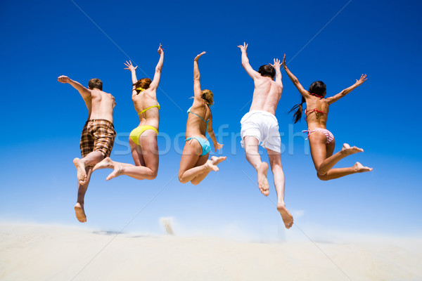 Ludzi portret skoki młodych ludzi plaży strony Zdjęcia stock © pressmaster