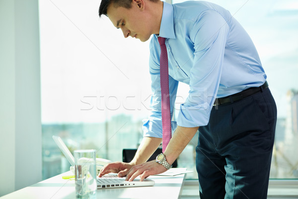 Bem sucedido empregador retrato homem local de trabalho datilografia Foto stock © pressmaster