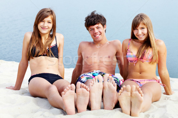 Nap melegség fiatalok ül homok napozás Stock fotó © pressmaster