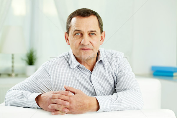 Dojrzały mężczyzna portret patrząc kamery posiedzenia sofa Zdjęcia stock © pressmaster
