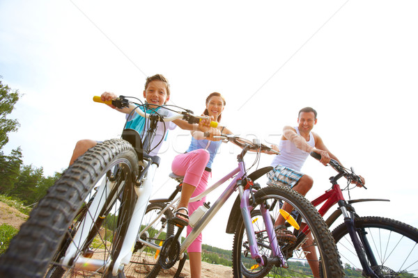 Familie weekend în aer liber trei şedinţei biciclete Imagine de stoc © pressmaster