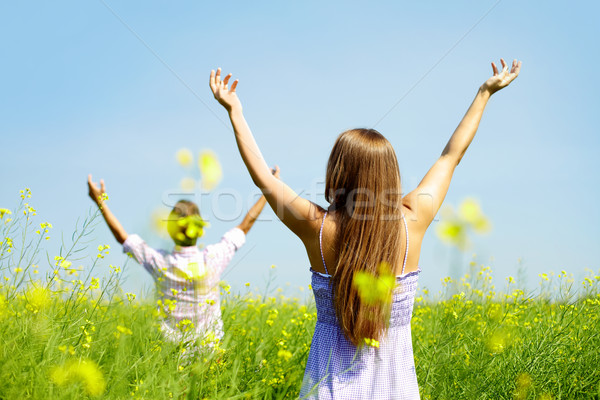 Dicsőség fiatal pér kiemelt karok áll virágmező Stock fotó © pressmaster