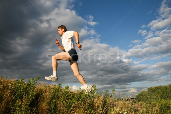 Vedere atlet jumping cer pădure Imagine de stoc © pressmaster