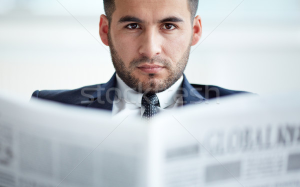 Poważny biznesmen młodych gazety patrząc kamery Zdjęcia stock © pressmaster