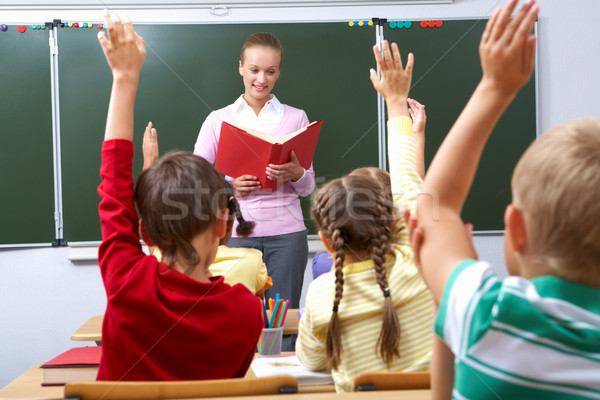 Hátsó nézet iskolás karok lecke tanár néz Stock fotó © pressmaster