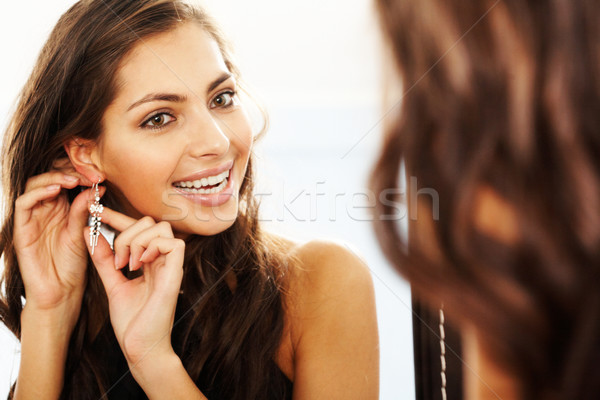Orecchini immagine bella femminile guardando specchio Foto d'archivio © pressmaster
