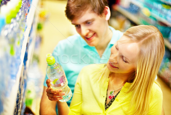 Supermercado imagem feliz casal escolher água mineral Foto stock © pressmaster